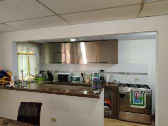 Modern kitchen with granite countertop, cabinets and gas stove in Cocoli La Chorrera house