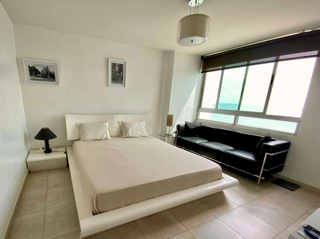 Ocean view bedroom with minimalist furnishings, large windows at PH Terrawind Panama City