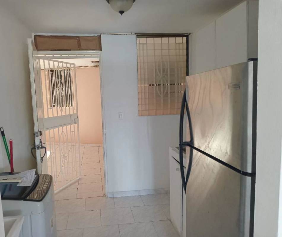 Kitchen with refrigerator, washer, security door, window with bars at Bella Vista Park Panama City