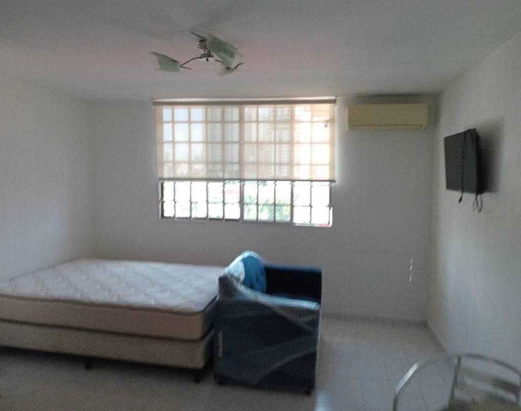 Minimalist bedroom living area with large window, mattress, sofa, air conditioning at Bella Vista Park Panama City