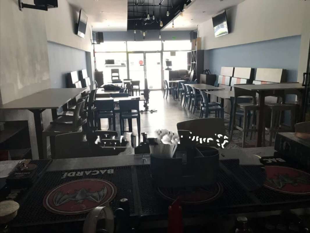 Dining tables, bar counter, TVs inside commercial retail unit in Condado del Rey