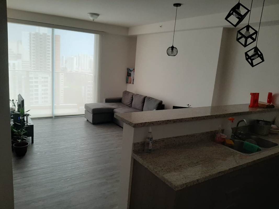 Living room with large glass sliding door to balcony overlooking city Panama
