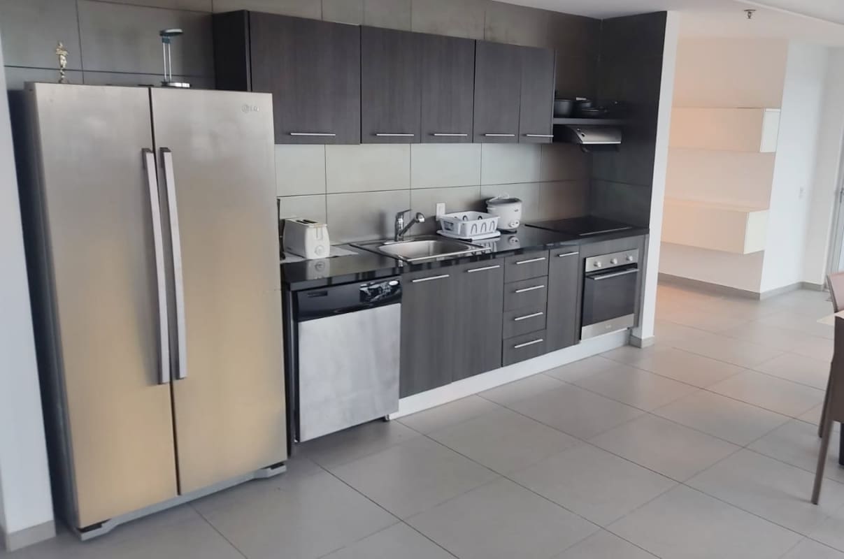 Fully equipped modern kitchen with dark wood cabinets, stainless steel appliances in PH BICSA Tower Panama City