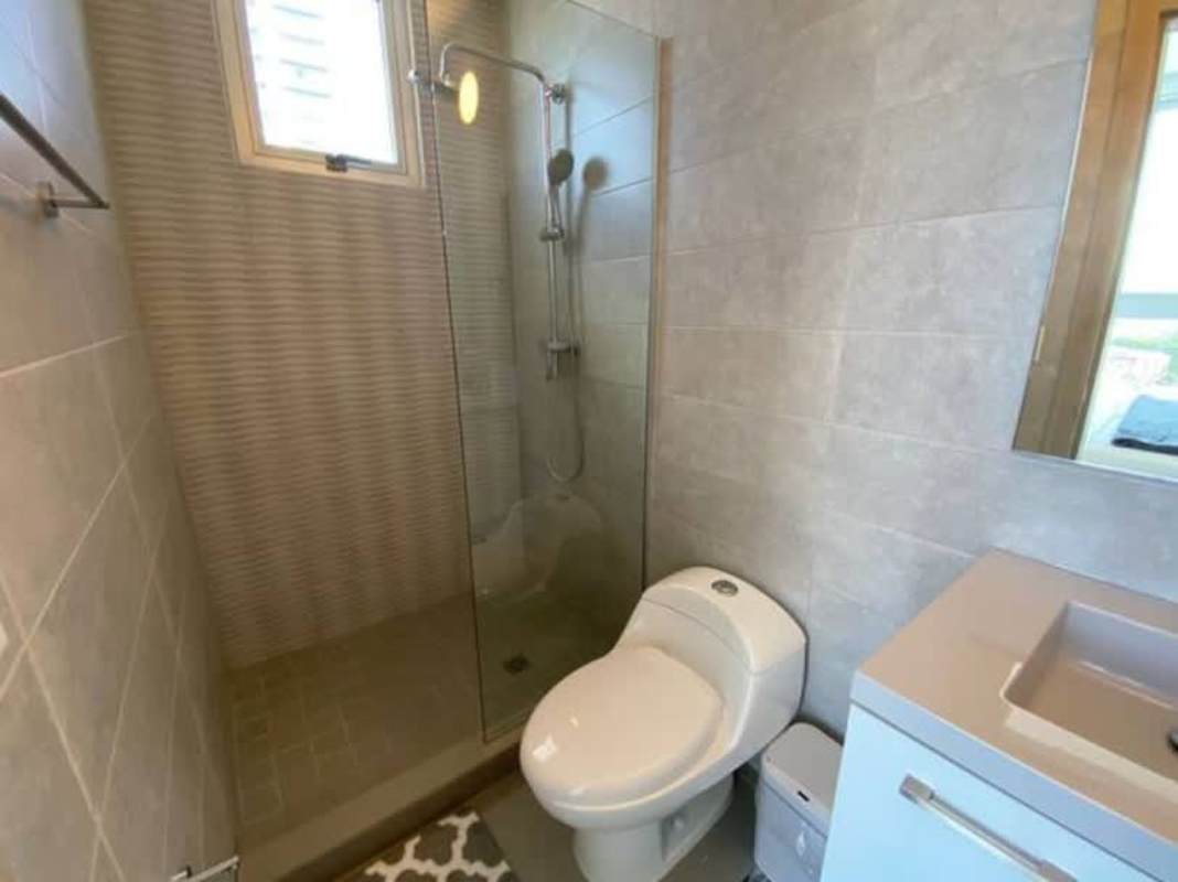 Living room with large glass doors and balcony, city views at PH Signature Point Panama City