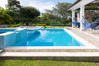 Modern living area with floor-to-ceiling windows and tropical garden view in Punta Barco Village beach house