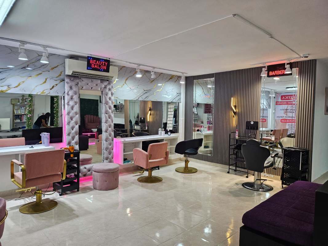 Modern glam salon with pink and black seating, marble walls, LED signs in Via España El Carmen area Panama