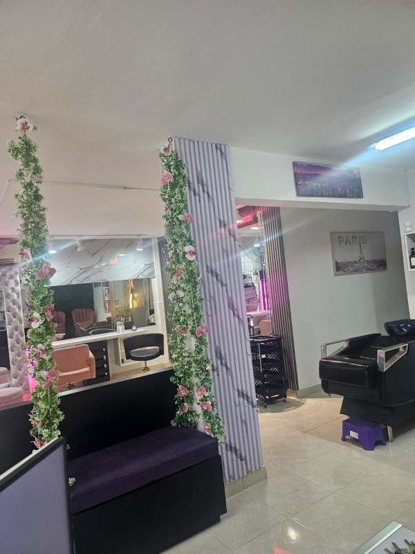 Modern beauty salon with marble feature wall, pink seats, neon signage Via España El Carmen Panama