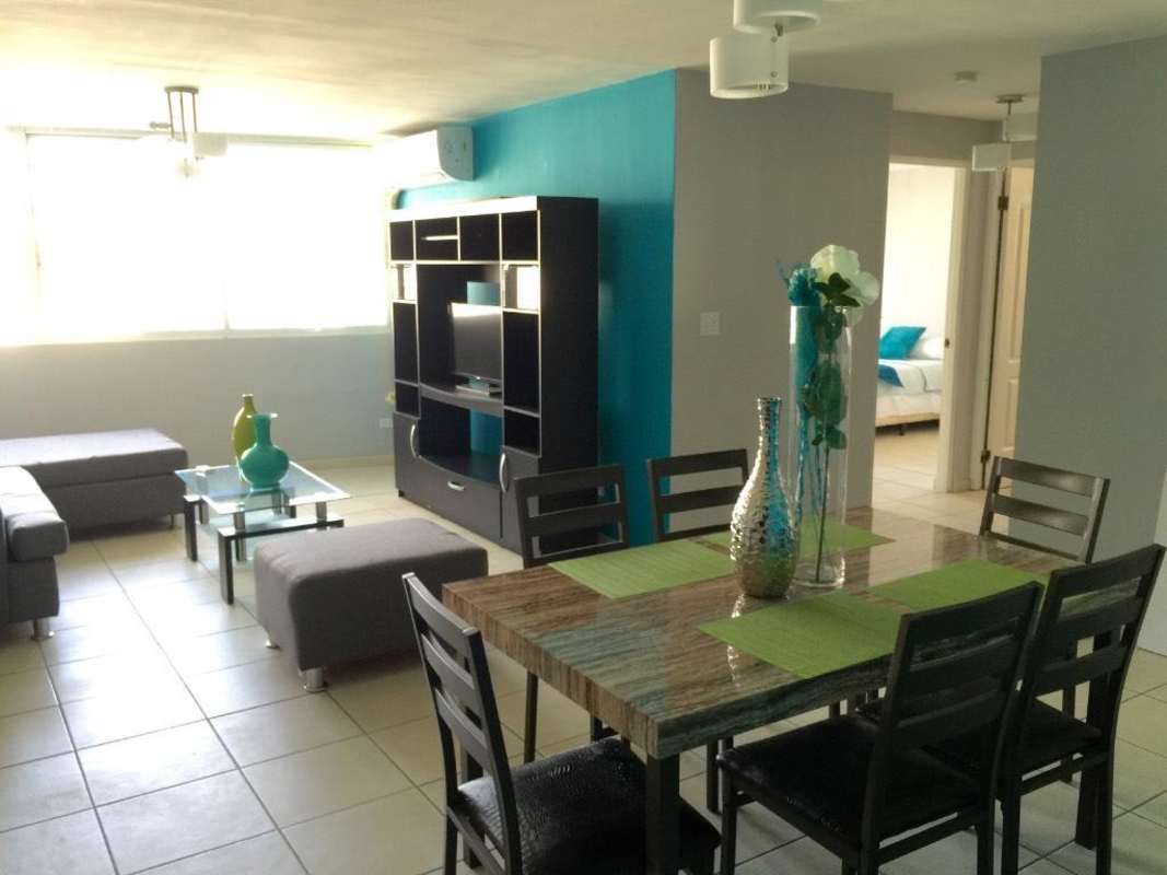 Spacious open-plan living and dining area with sectional sofa, entertainment center, dining table, PH Torre Mar del Sur Panama
