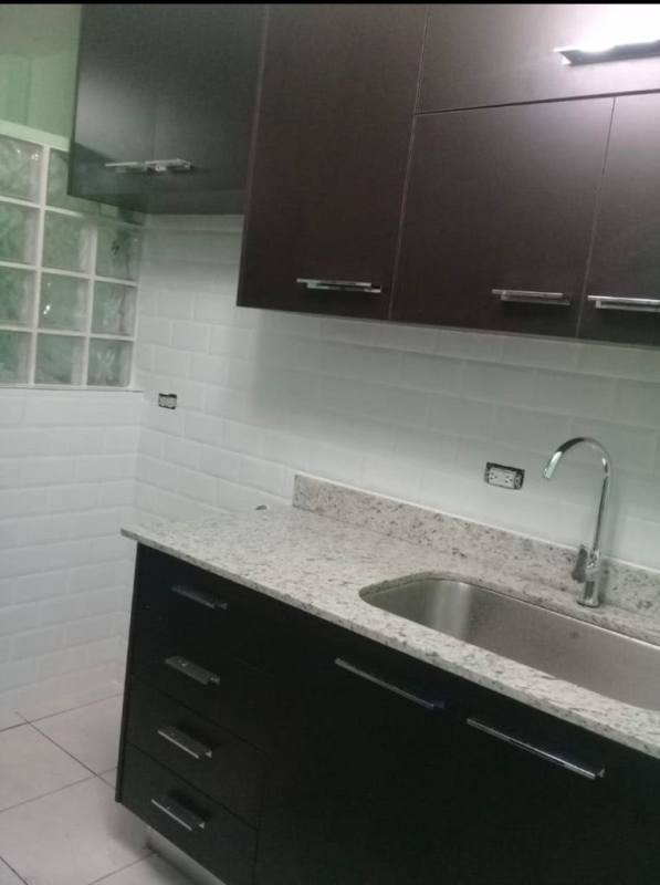 Kitchen with granite countertop, dark wood cabinets, subway tile backsplash at PH Torre Mar del Sur San Francisco Panama