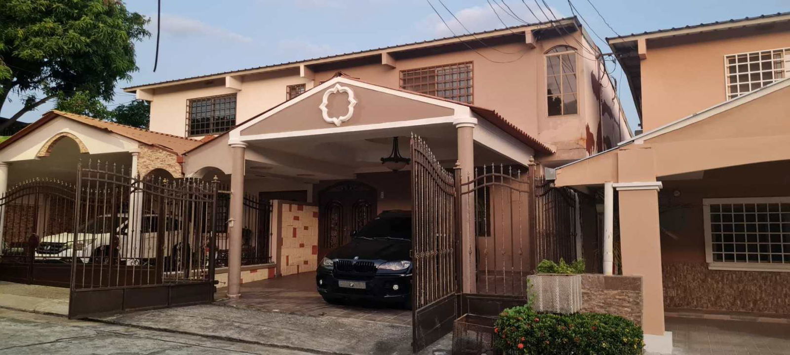 View of spacious two-story gated house with carport in Brisas del Golf Panama for rent