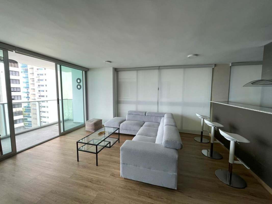 Open-plan living dining area with sectional sofa and glass table PH Lumiere Costa del Este Panama