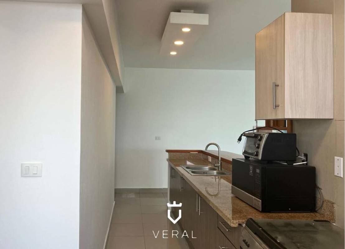 Contemporary kitchen with granite countertops built-in appliances bright cabinetry PH Harmony Panama City