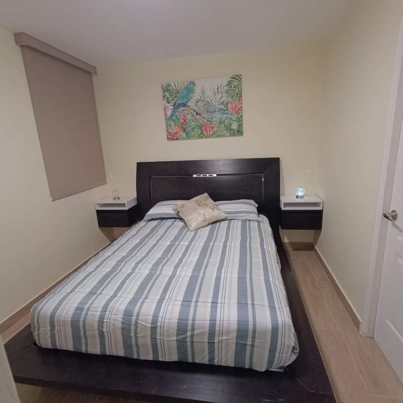 Bedroom with striped bedding, floating nightstands, neutral decor in PH San Francisco Bay Panama