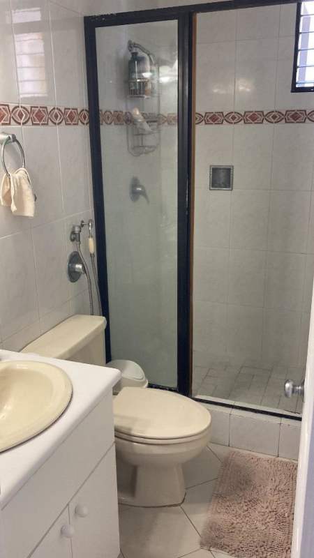 Compact bathroom with enclosed shower and sink vanity in PH Paitilla Panama City