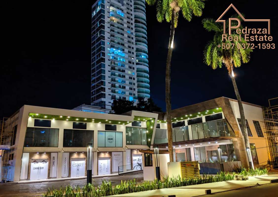 Modern commercial plaza with glass facade illuminated at night Coco del Mar Panama