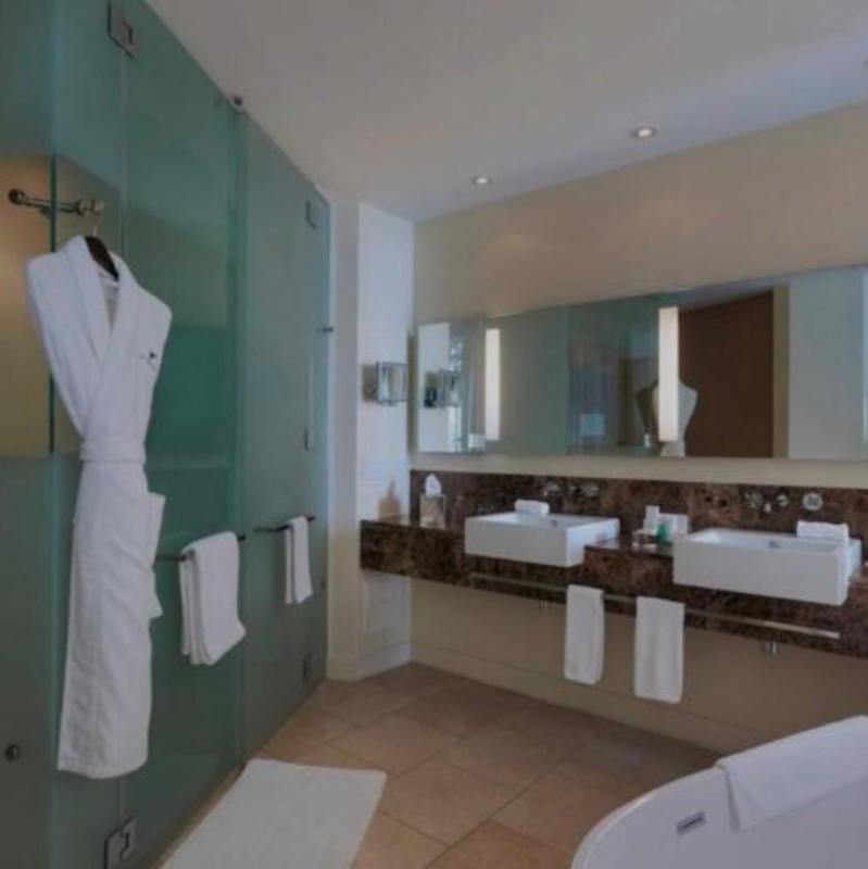 Modern bathroom featuring glass shower, double vanity, marble top at JW Marriott Panama