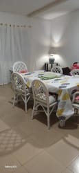 Dining table with wicker chairs and decorative tablecloth near window inside furnished house in Las Lajas near Coronado
