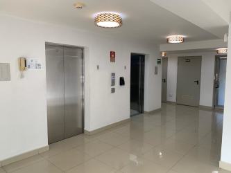 Kitchen equipped with granite countertops, appliances, and wood cabinetry at Midrise Tower 5