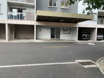 Living and dining room with large sliding doors opening to balcony in Woodlands Panama Pacifico