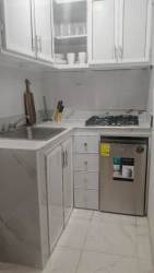 Compact cabin kitchen white cabinets granite counter mini fridge microwave La Laguna Panama