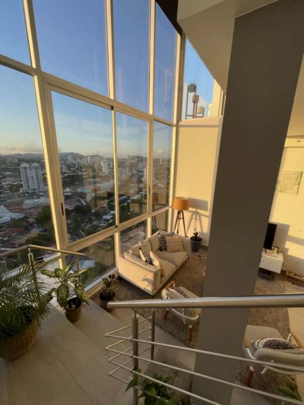 Open living and dining loft with panoramic sunset skyline views in Sky Park Tower