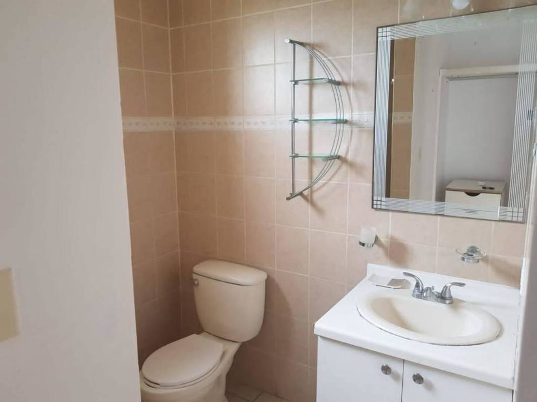 Modern bathroom with vanity beige tiles wall mirror and fixtures in PH Nuova Villa de la Fuentes Panama City