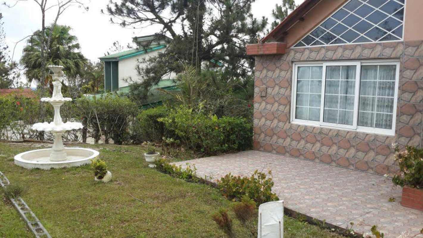 Well-maintained garden with fountain hedges and tropical plants Cerro Azul mountain house Panama