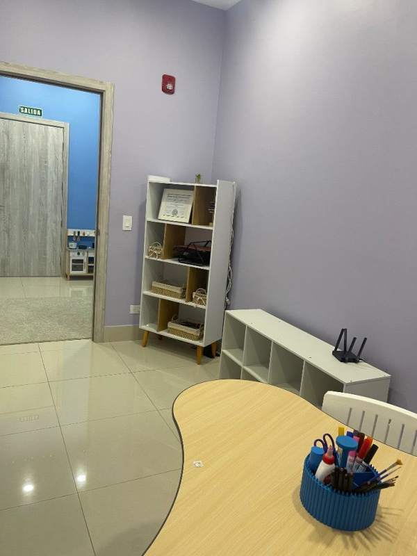 Organized pediatric consultation room with toys, desk, shelving Medical Center Costa del Este