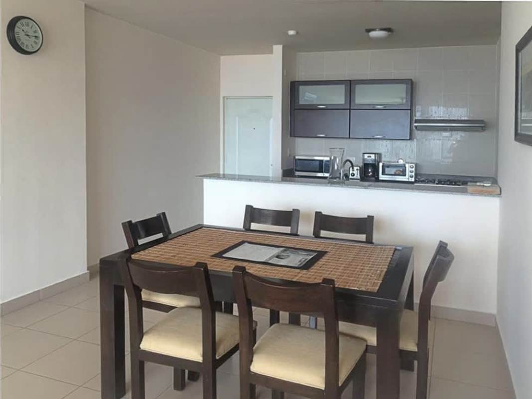 Open kitchen and dining space with appliances and dining table in furnished Panama apartment PH Met San Francisco.