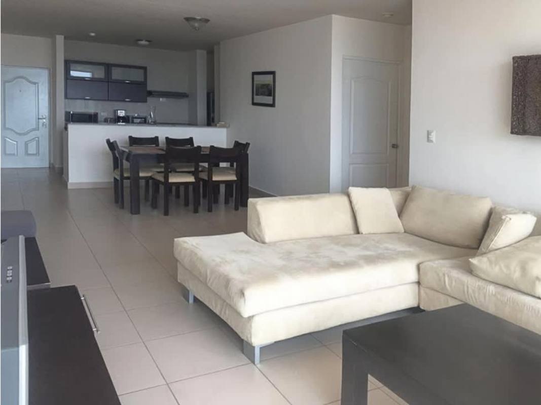 Open plan living and dining area with sofa, dining set, tile floors at PH Met San Francisco.