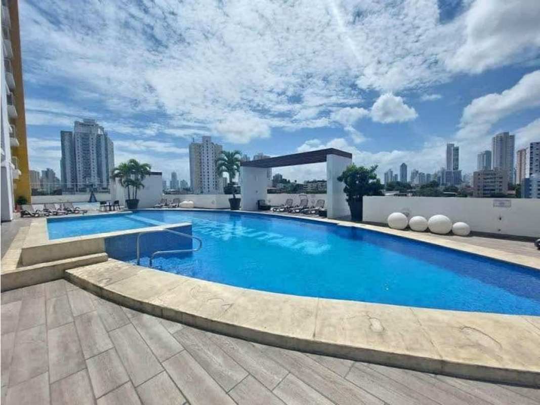 Outdoor swimming pool with lounge chairs, skyline view at PH Carrasquilla Tower Panama