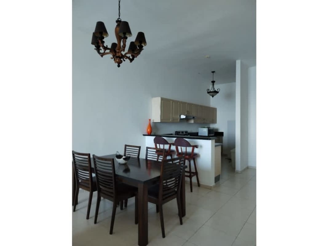 Open concept dining and kitchen space with breakfast bar and pendant lights in PH Vista del Mar Panama
