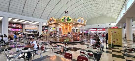 Spacious food court with carousel, dining seating and restaurants inside Westland Mall Panama Oeste