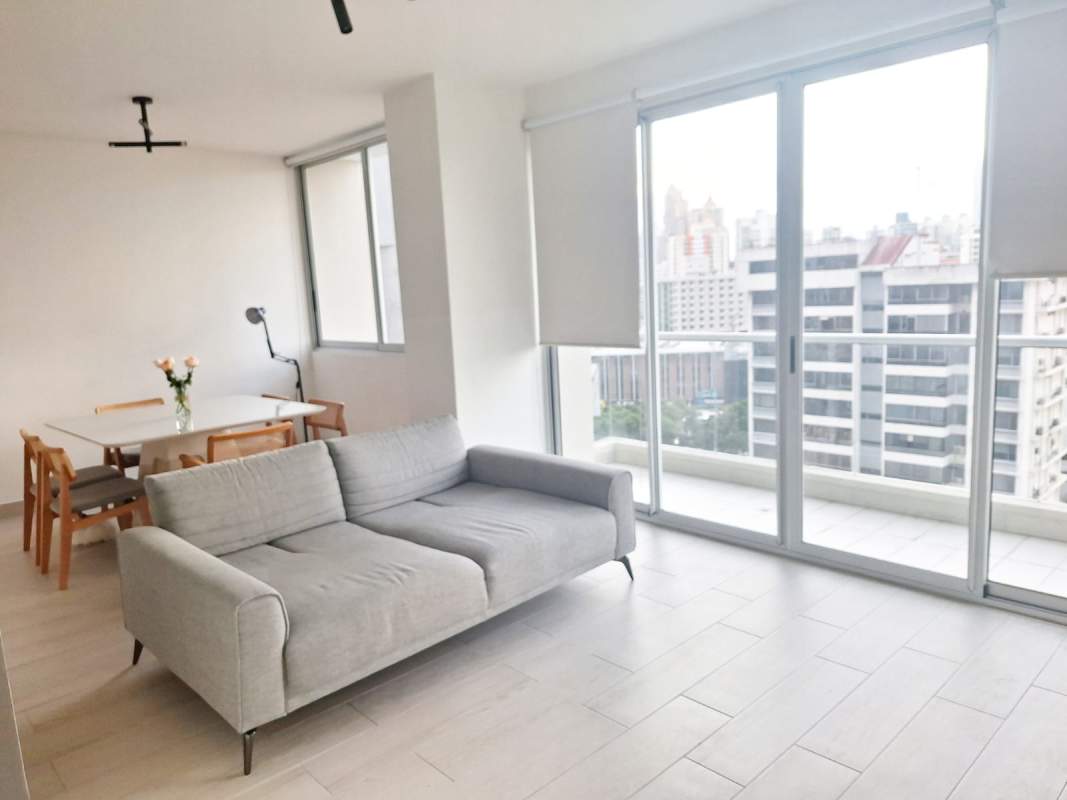 Living room with comfortable furniture and balcony with city view in PH Urbana Obarrio Panama City