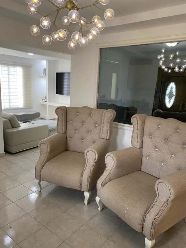 Contemporary living room with beige armchairs, sectional sofa, tile floors in Residencial Santa Fe Panama