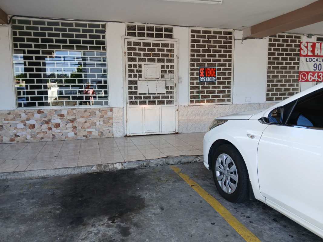 Metal grilles on commercial property and white parked car at Parque Lefevre Panama