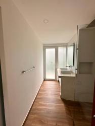 Modern ensuite bathroom with glass shower, vanity and natural finishes in luxury house Tucan Country Club