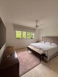 Master bedroom with sofa, large windows, TV console in Tucan Country Club Panama