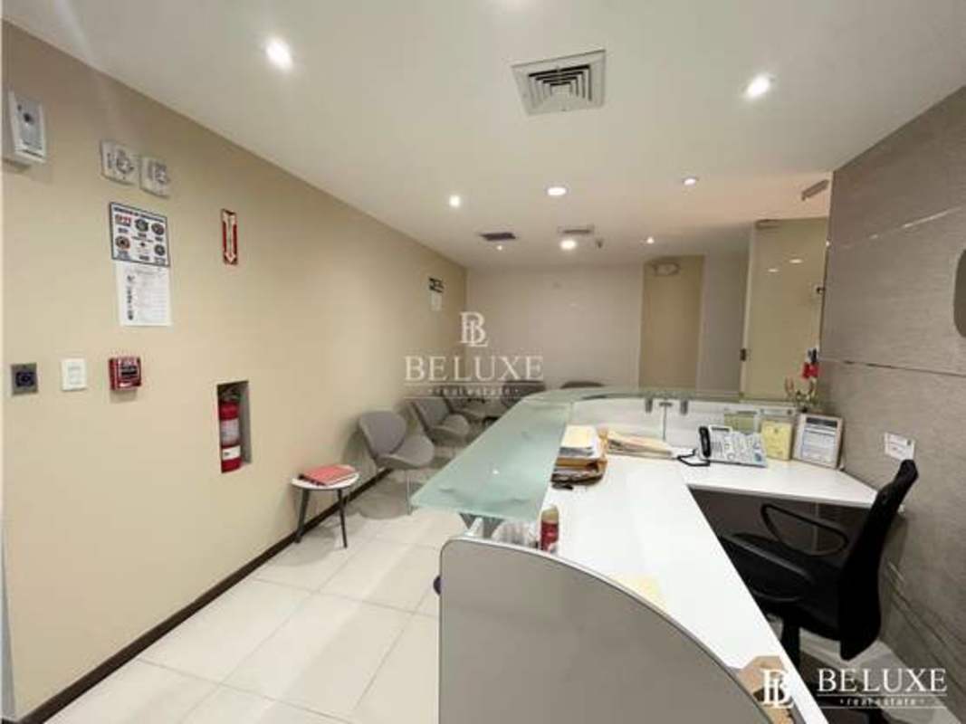 Reception area with curved glass desk and lounge furniture in Oceania Business Plaza