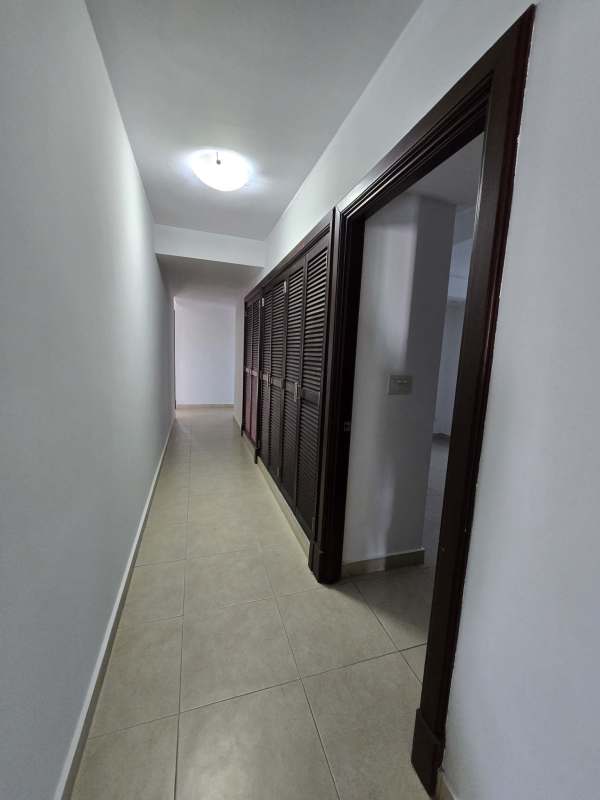 Long corridor with dark wooden closets marble floors PH Golf Tower Panama
