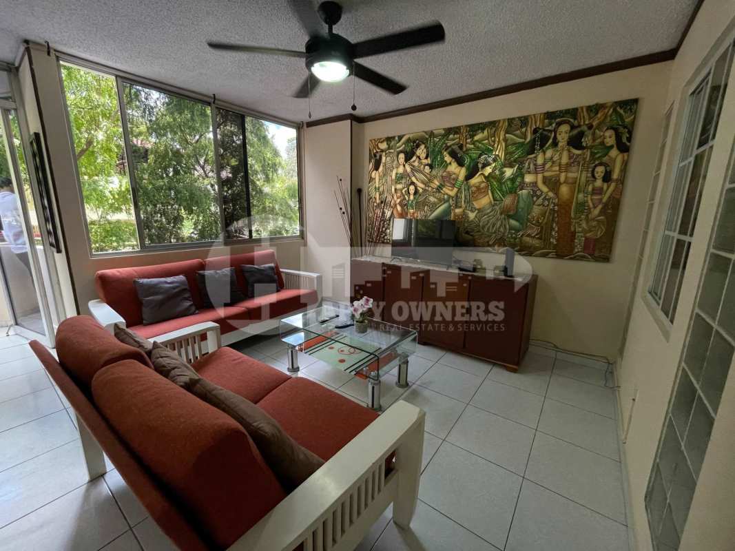Bright living room with large windows, red sofas, ceiling fan, tiled floor PH Del Caribe El Cangrejo Panama