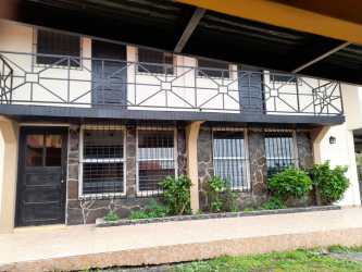 Spacious living room with peach accent wall and window in two house property Volcán Panama