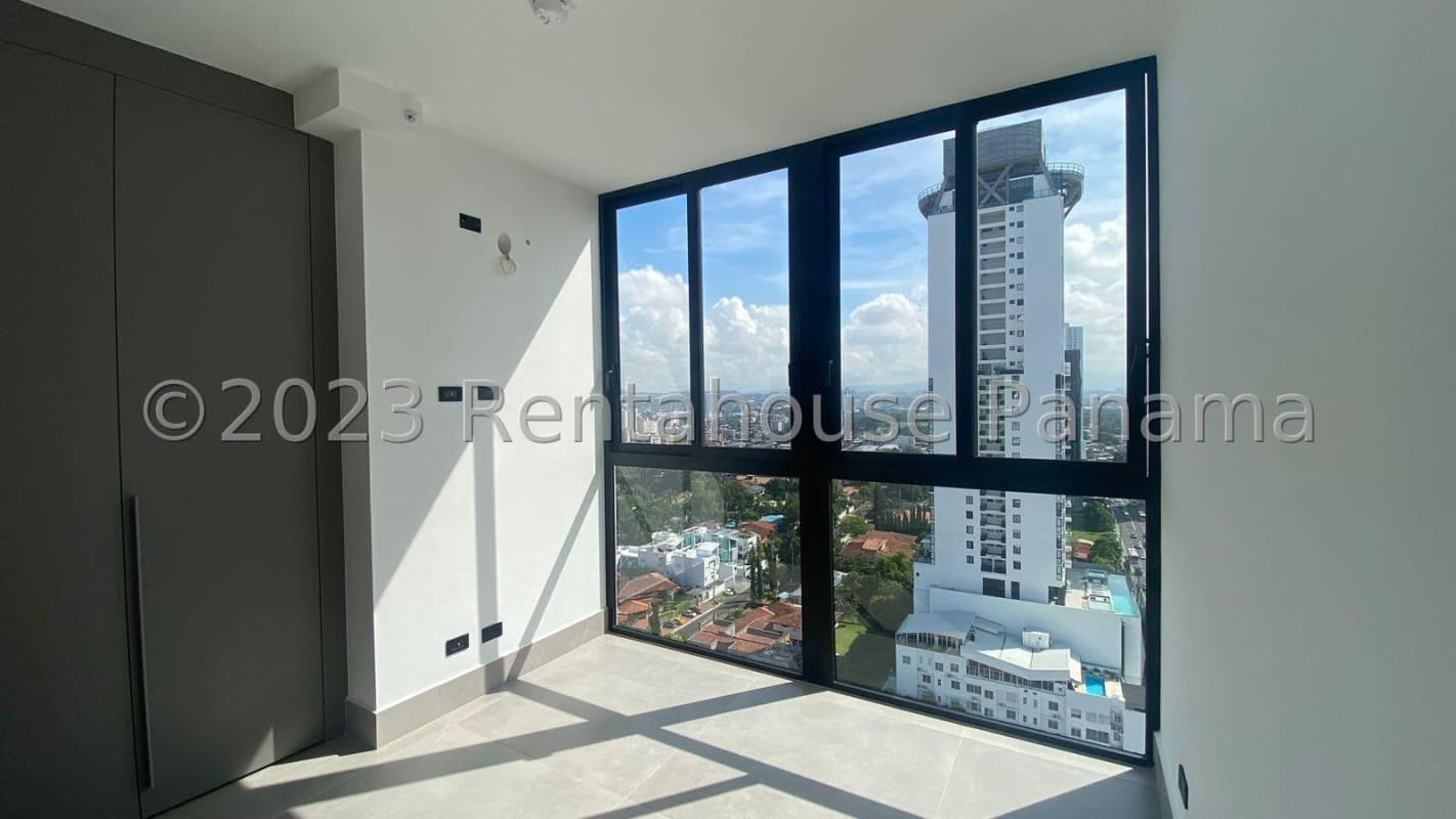 Spacious master bedroom with floor-to-ceiling windows, built-in closet, AC, and panoramic ocean city view in Coco del Mar rental