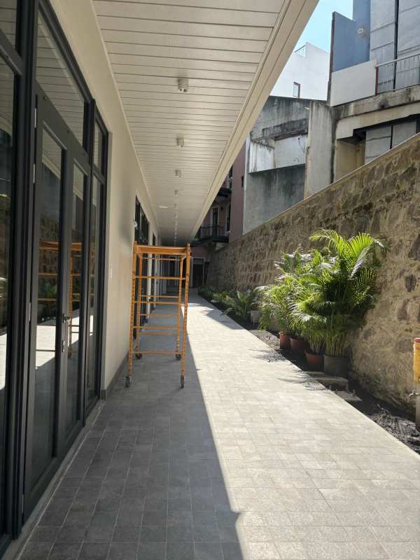 Industrial style stairwell with concrete stairs, glass windows, and fire sprinkler pipe in commercial plaza Casco Viejo Panama