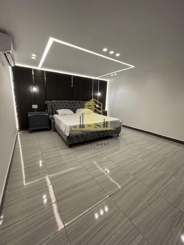Modern bedroom with tufted bed, black accent wall, and LED lighting Altos de Panamá