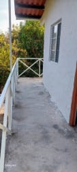 White two-story cabin with fenced yard surrounded by trees Las Guias Panama