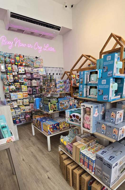 Modern retail interior with neon sign, organized shelving, and colorful toys inside Casa Baby San Francisco Panama