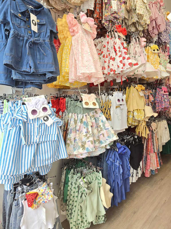 Kids clothing displays with colorful dresses on racks in Casa Baby boutique Panama City