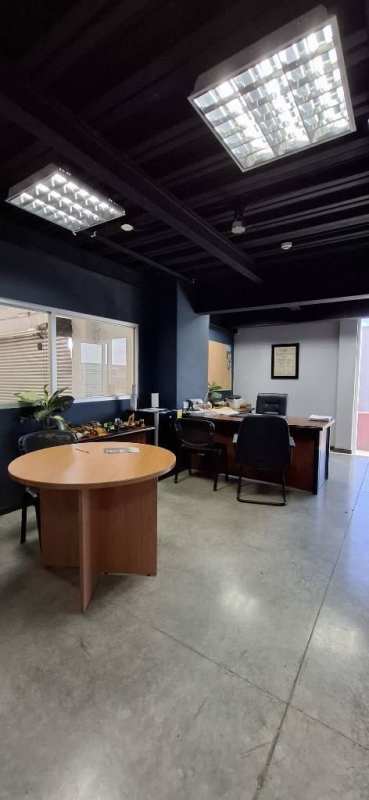 Industrial style office with exposed ceiling, glass partitions, meeting table in Pacora Commercial Complex Panama