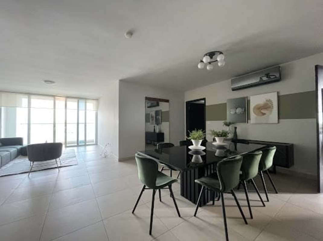 Dining space with black glass table and green chairs in modern apartment Costa del Este
